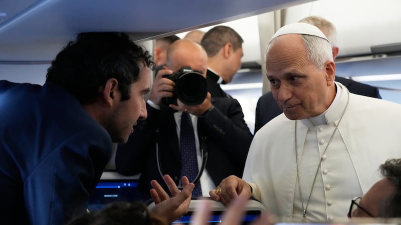 Pope Leo XIV talks to journalists aboard the papal flight from Rome to Paris, Friday, Sept....