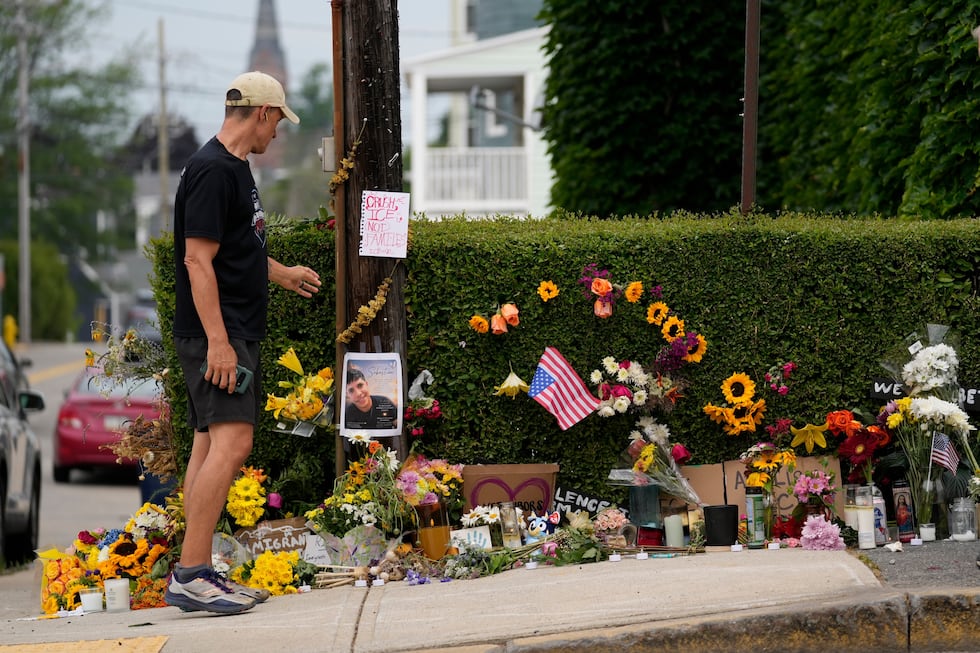 A man pauses to view a makeshift memorial to the victim of a shooting involving U.S....